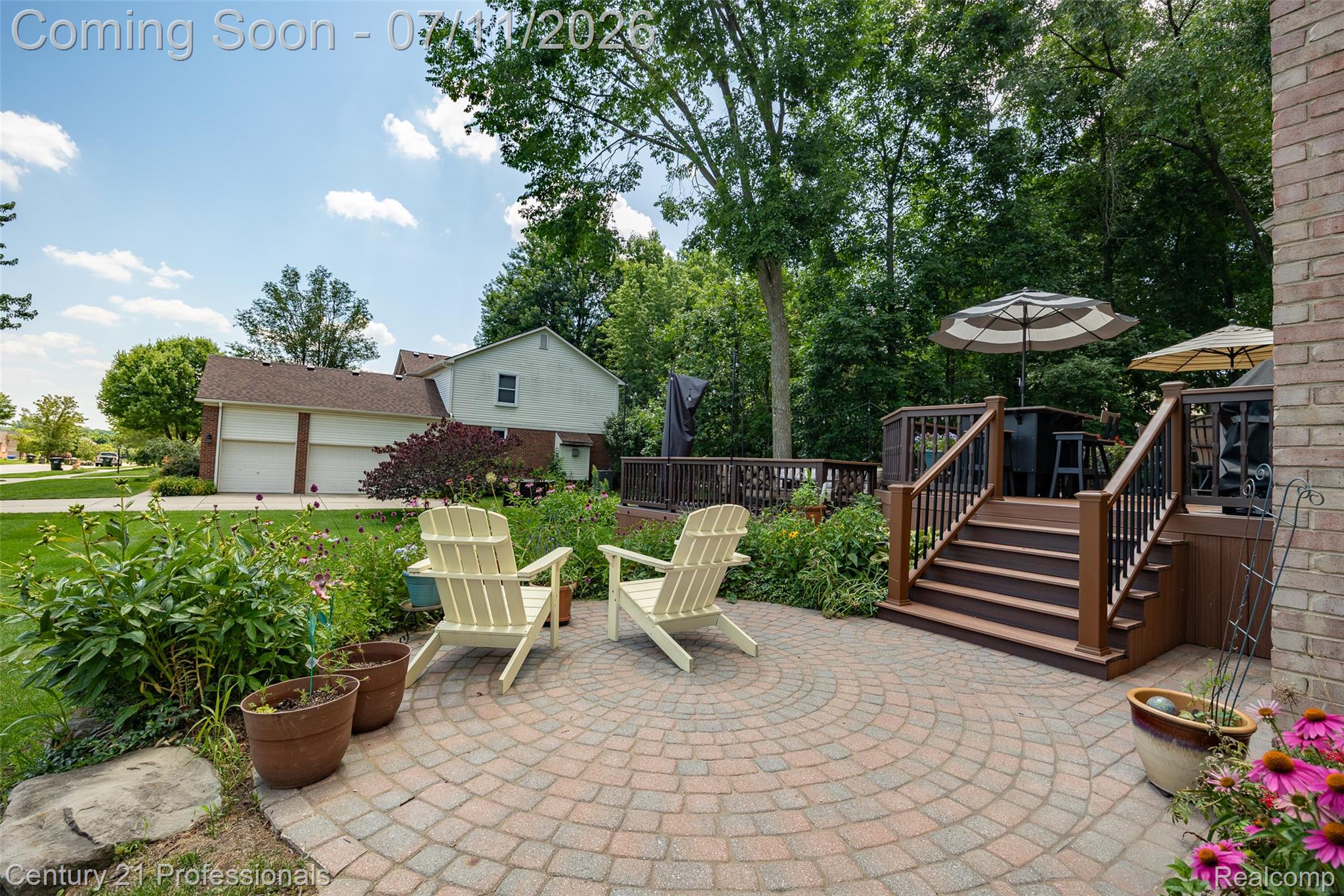 689 Woodfield Way Rochester, MI 48307 - Photo 7 of 61 Circular paver patio with a surrounding garden bed and mature plantings