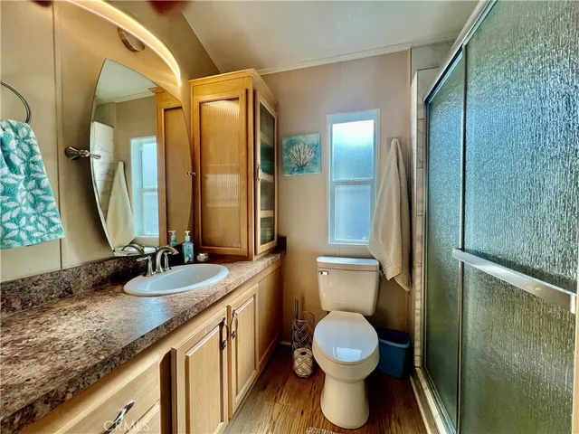 a bathroom with a granite countertop sink toilet and shower