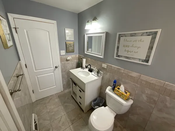 a bathroom with a sink vanity mirror and toilet