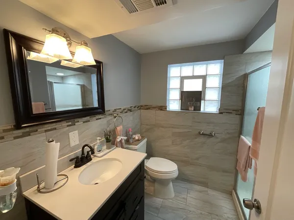 a bathroom with a sink vanity mirror and toilet
