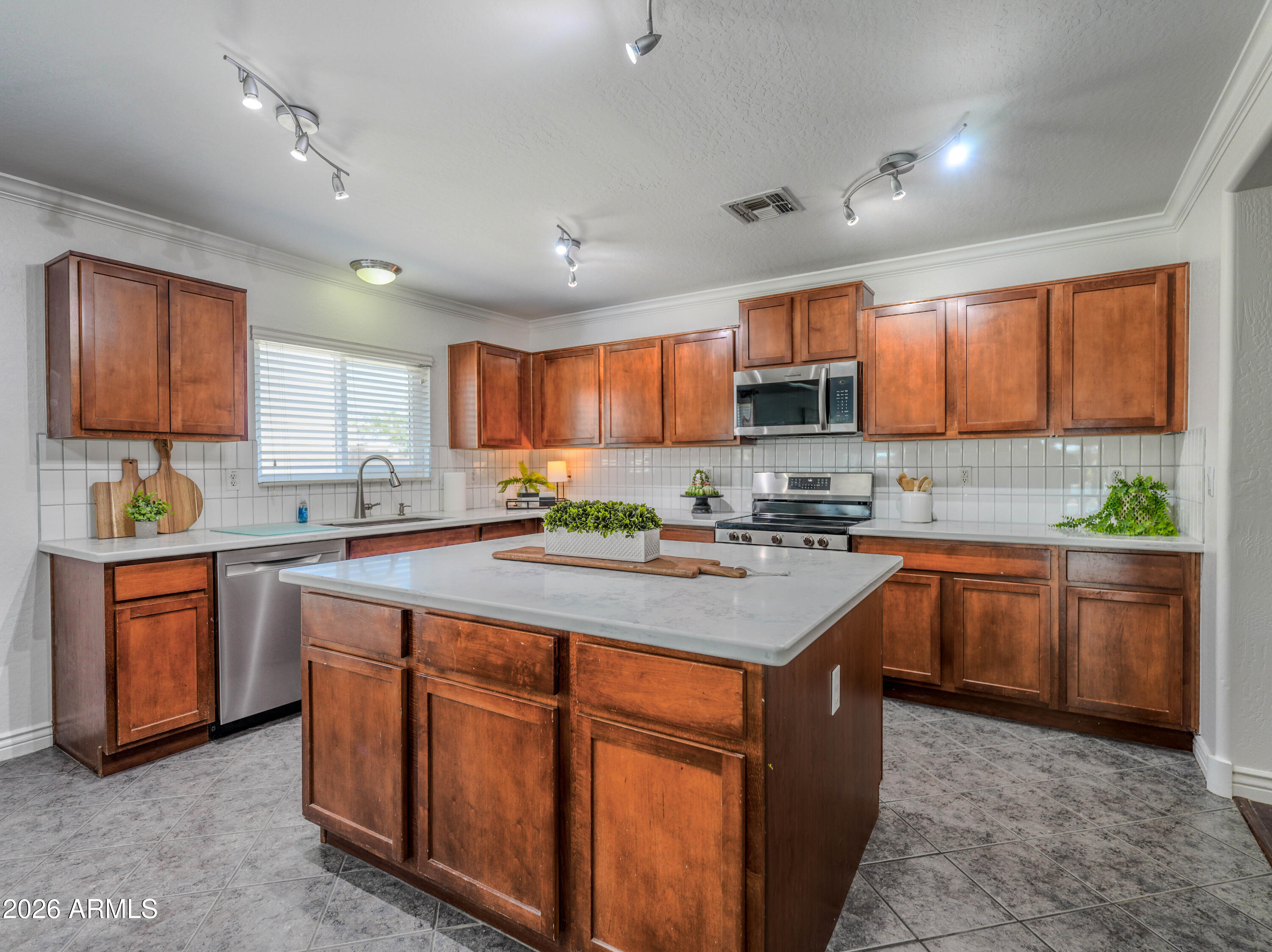3378 East Silverbell Road San Tan Valley, AZ 85143 - Photo 20 of 61 a kitchen with stainless steel appliances granite countertop a stove sink microwave and cabinets