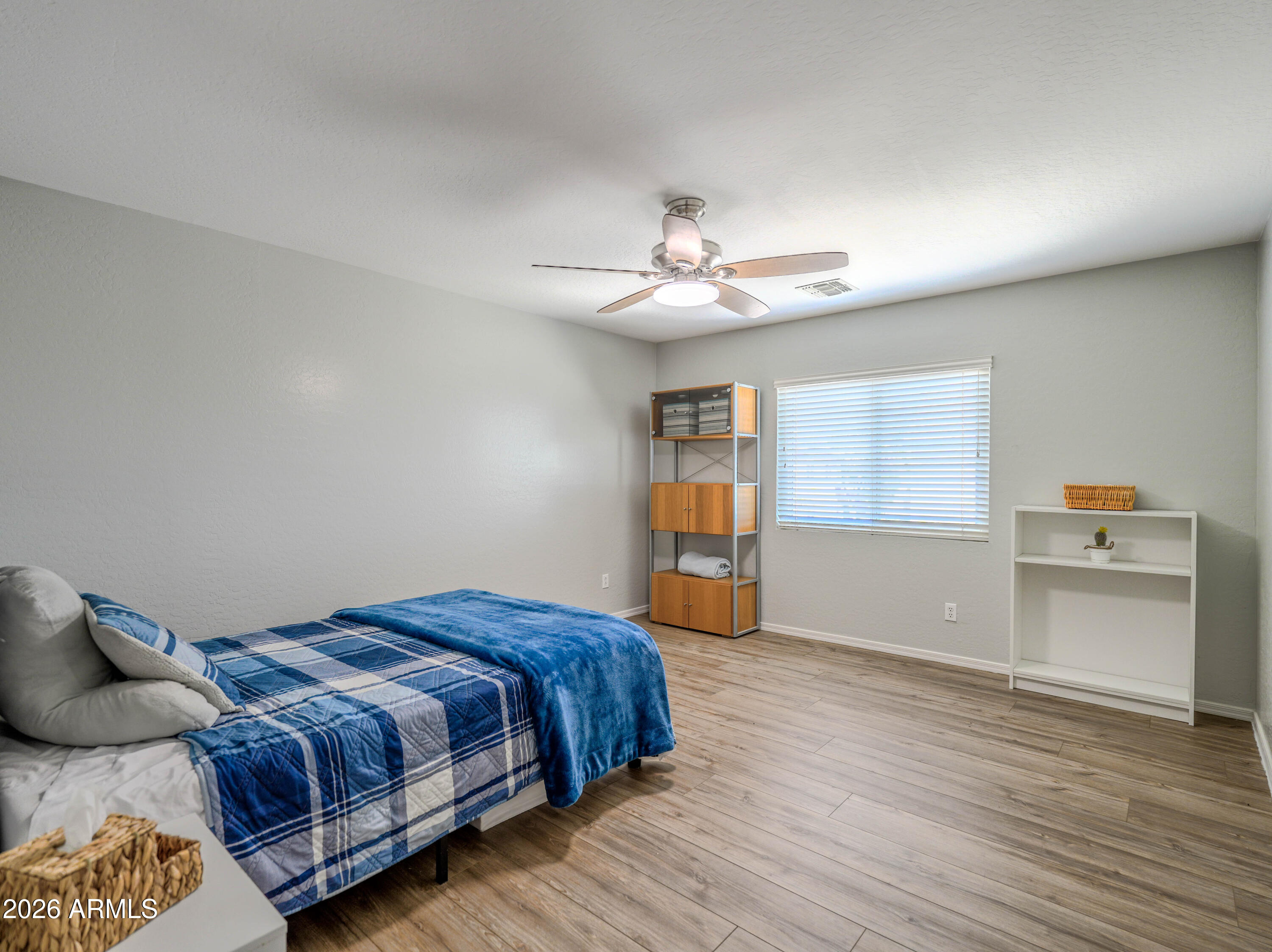 3378 East Silverbell Road San Tan Valley, AZ 85143 - Photo 43 of 61 a bedroom with a bed and a chandelier