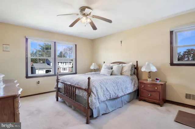 a spacious bedroom with a bed a wall painting on the wall and a window