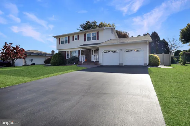 a front view of a house with a garden and yard