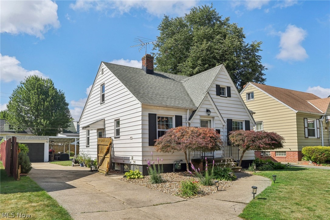 View of front facade featuring a garage and a front lawn