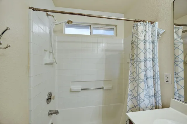 a bedroom with a large bed a flat tv screen and a chandelier