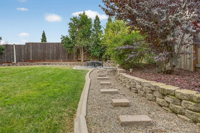a white bench sitting in the middle of a park with potted plants
