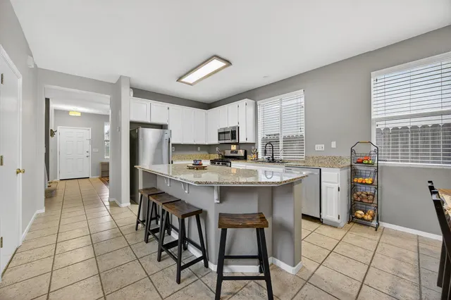 a kitchen with stainless steel appliances kitchen island granite countertop a sink and cabinets
