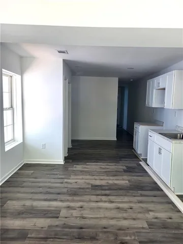 a view of kitchen with granite countertop cabinets and window
