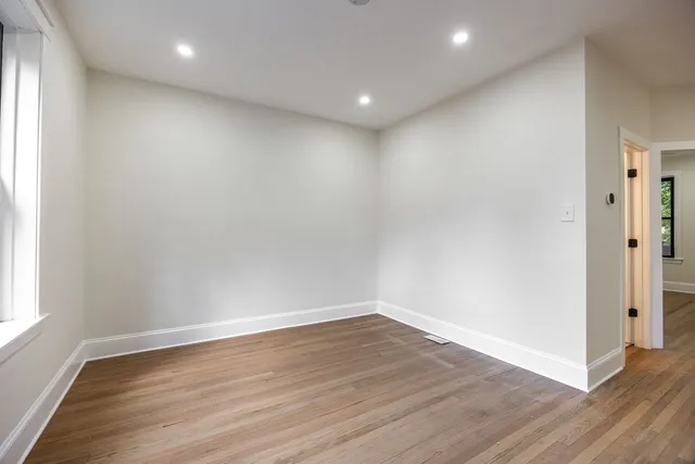 a view of a hallway with wooden floor and closet area