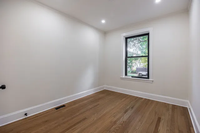 wooden floor in an empty room with a window