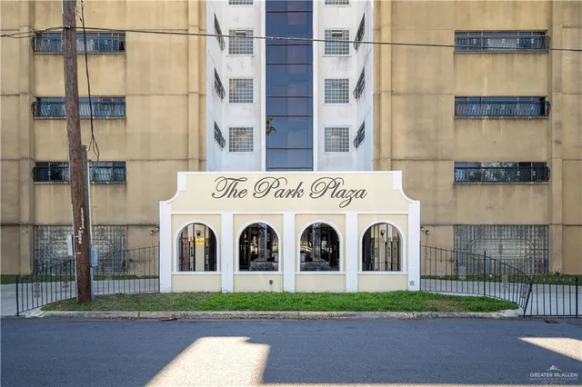 a view of a white building with a yard