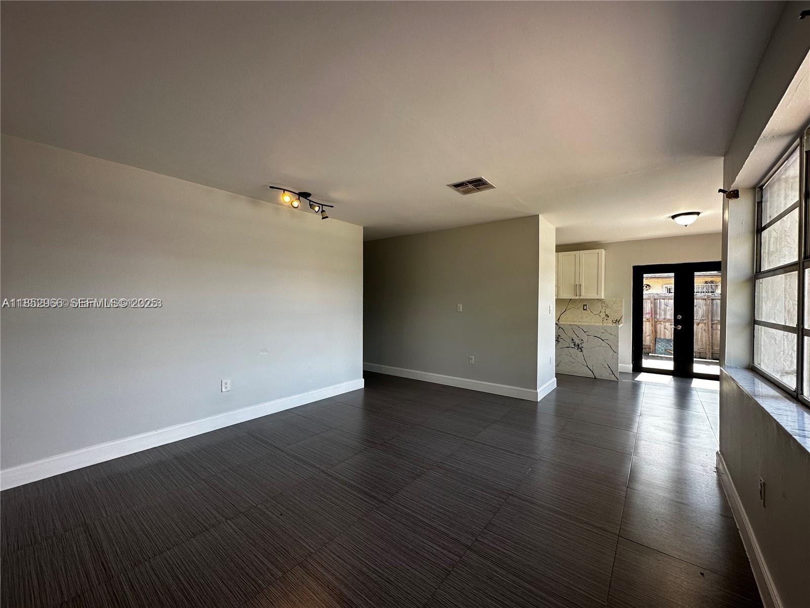 11549 Southwest 4th Street Sweetwater, FL 33174 - Photo 2 of 8 a view of an empty room with wooden floor and a window
