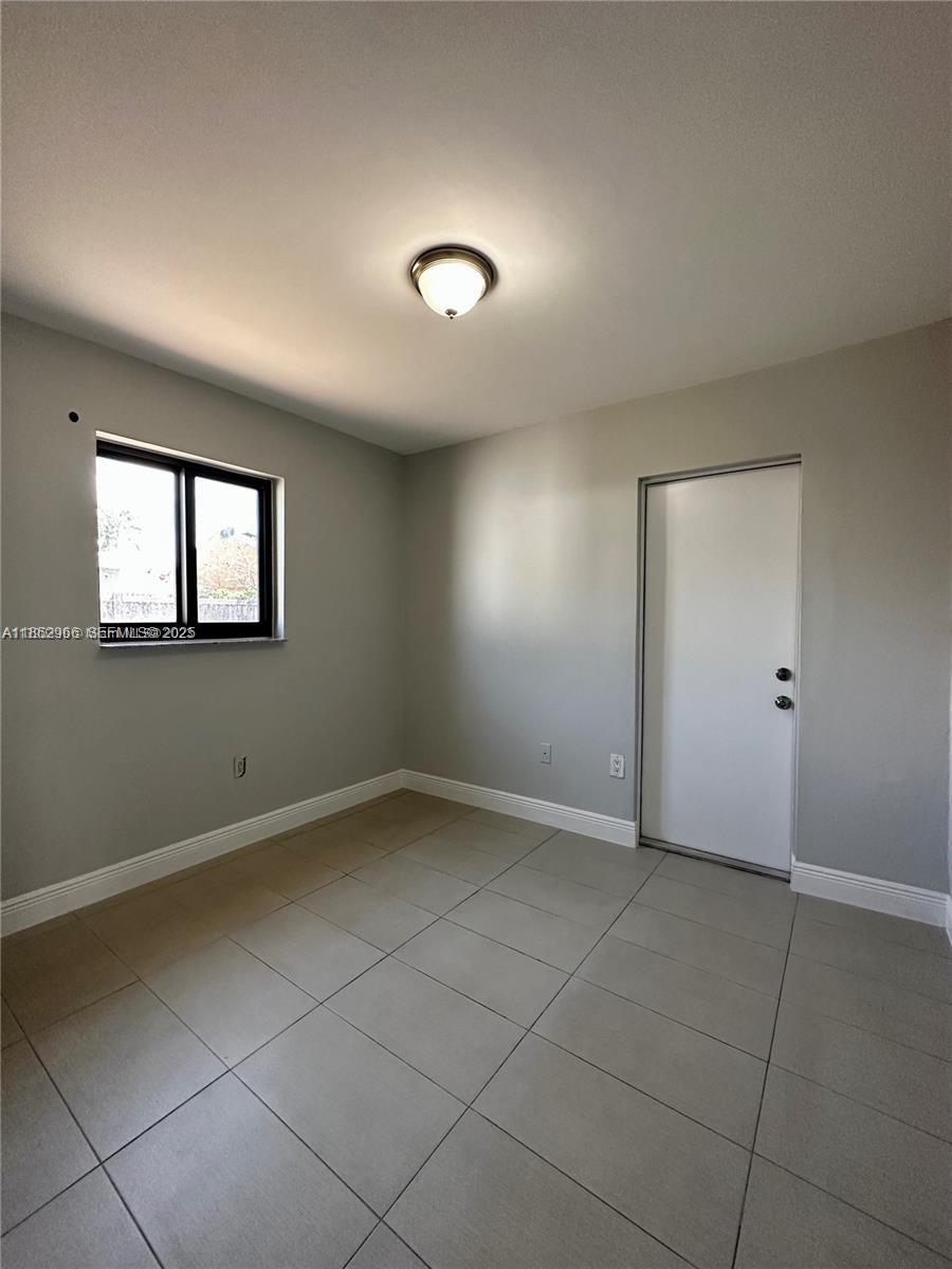 11549 Southwest 4th Street Sweetwater, FL 33174 - Photo 5 of 8 an empty room with a empty space and windows
