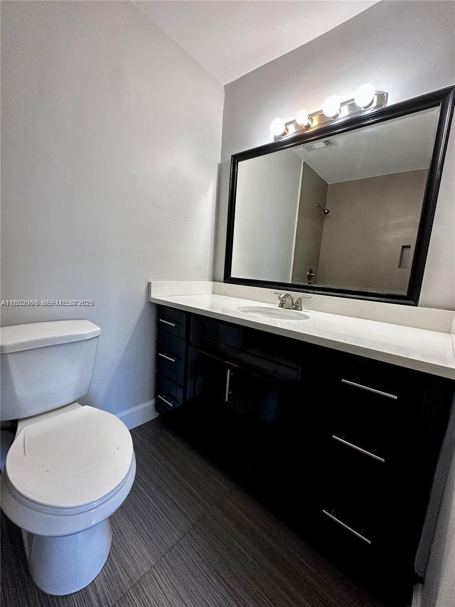 11549 Southwest 4th Street Sweetwater, FL 33174 - Photo 6 of 8 a bathroom with a toilet sink and mirror