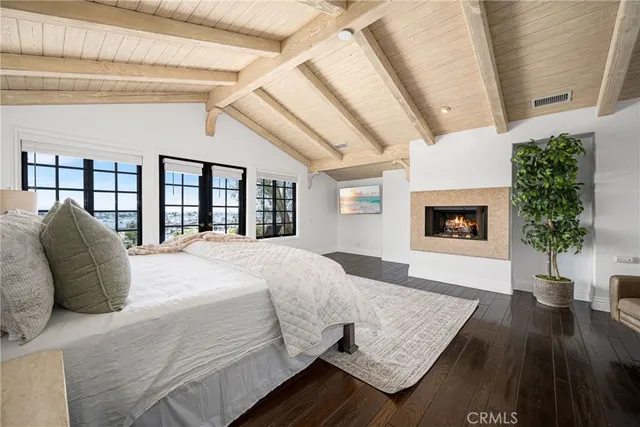 a spacious bedroom with a bed a dresser next to a window