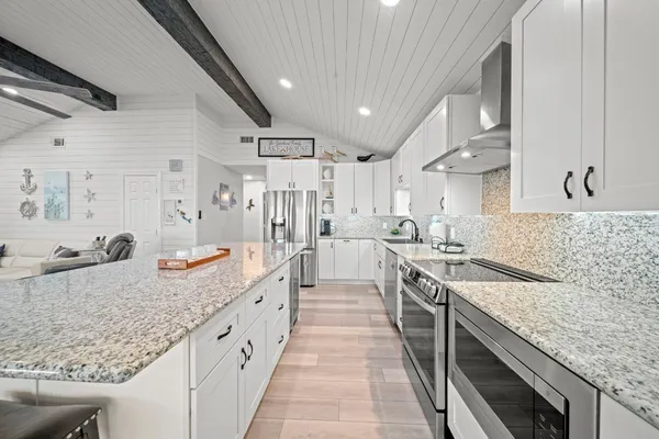 a kitchen with stainless steel appliances granite countertop a sink stove and refrigerator