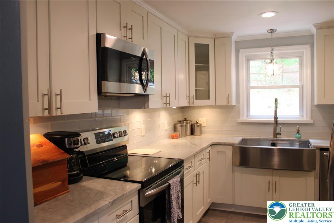 635 Silver Spring Boulevard Kunkletown, PA 18058 - Photo 12 of 34 a kitchen with stainless steel appliances a stove a sink and a microwave