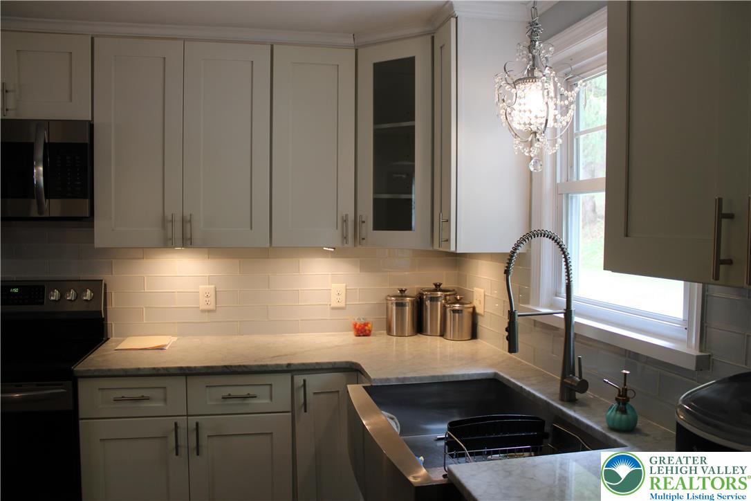 635 Silver Spring Boulevard Kunkletown, PA 18058 - Photo 13 of 34 a kitchen with stainless steel appliances a sink a stove cabinets and a window