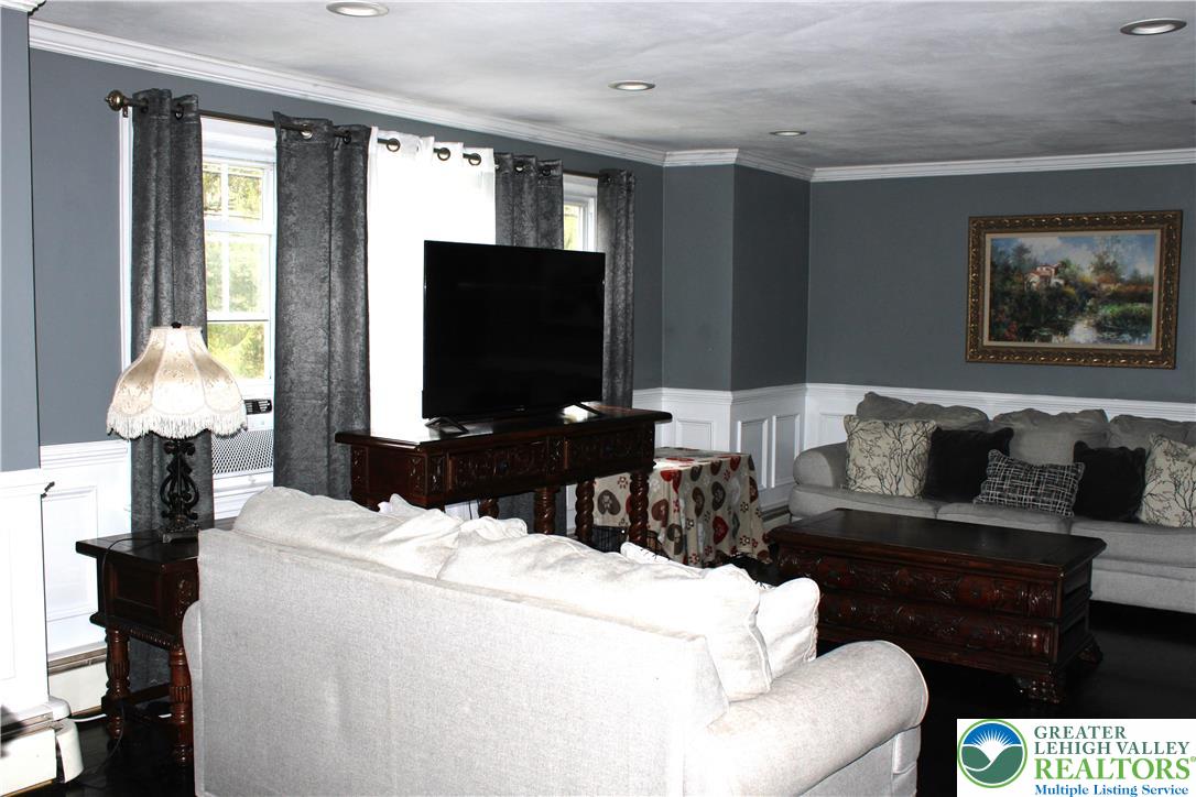 635 Silver Spring Boulevard Kunkletown, PA 18058 - Photo 24 of 34 a living room with furniture a flat screen tv and a floor to ceiling window