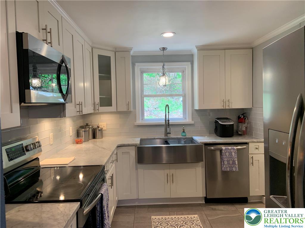 635 Silver Spring Boulevard Kunkletown, PA 18058 - Photo 10 of 34 a kitchen with stainless steel appliances granite countertop a sink stove and refrigerator