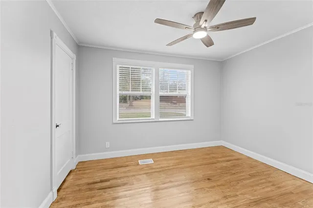 an empty room with a window and a ceiling fan