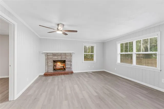 an empty room with windows and a fireplace