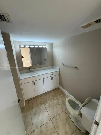 a bathroom with a sink a toilet and mirror