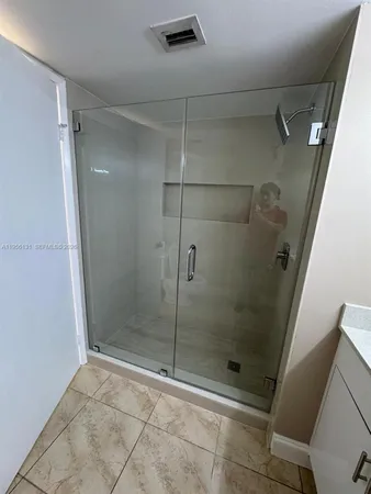 a bathroom with a glass door shower