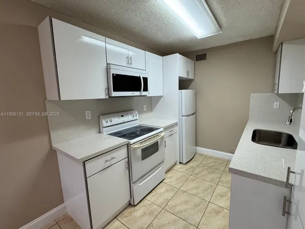 a kitchen with a stove a microwave and refrigerator