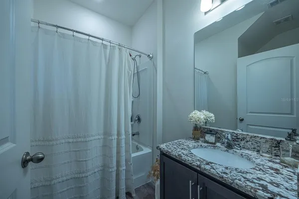a bathroom with a granite countertop sink and a mirror