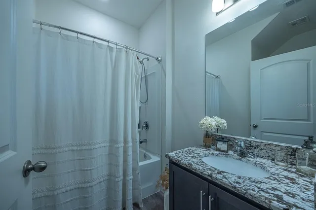 a bathroom with a granite countertop sink and a mirror