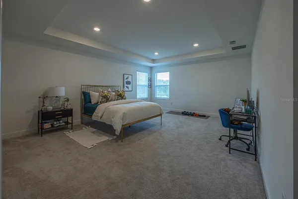 a spacious bedroom with a bed and a desk in it