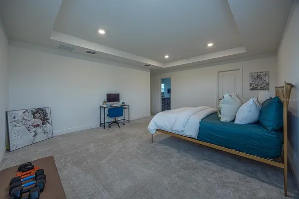 a spacious bedroom with a bed and a chandelier