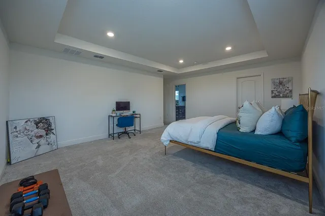 a spacious bedroom with a bed and a chandelier