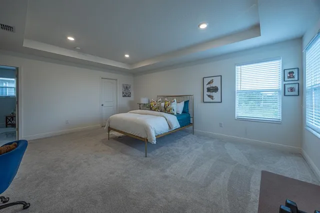 a spacious bedroom with a bed and a window