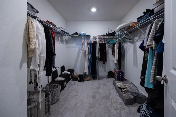 a view of walk in closet with clothes and shoes
