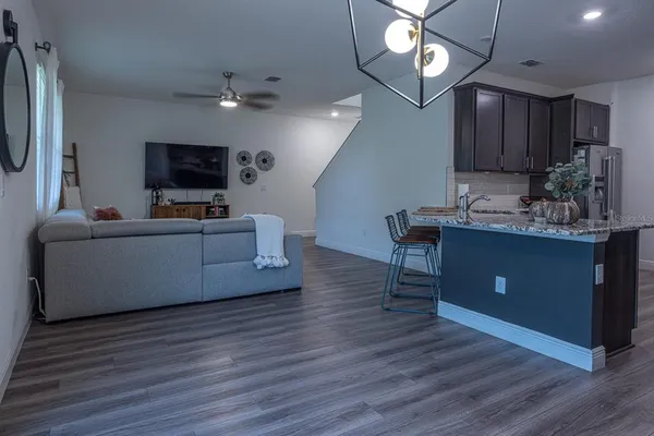 a living room with furniture a flat screen tv and kitchen view