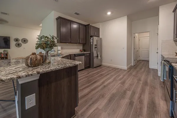 a kitchen with stainless steel appliances granite countertop a sink stove and refrigerator