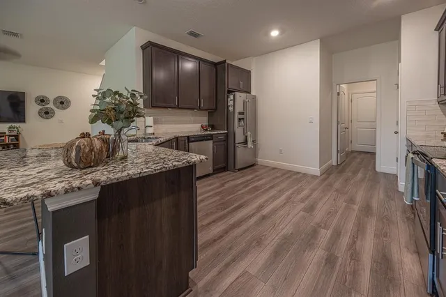 a kitchen with stainless steel appliances granite countertop a sink stove and refrigerator