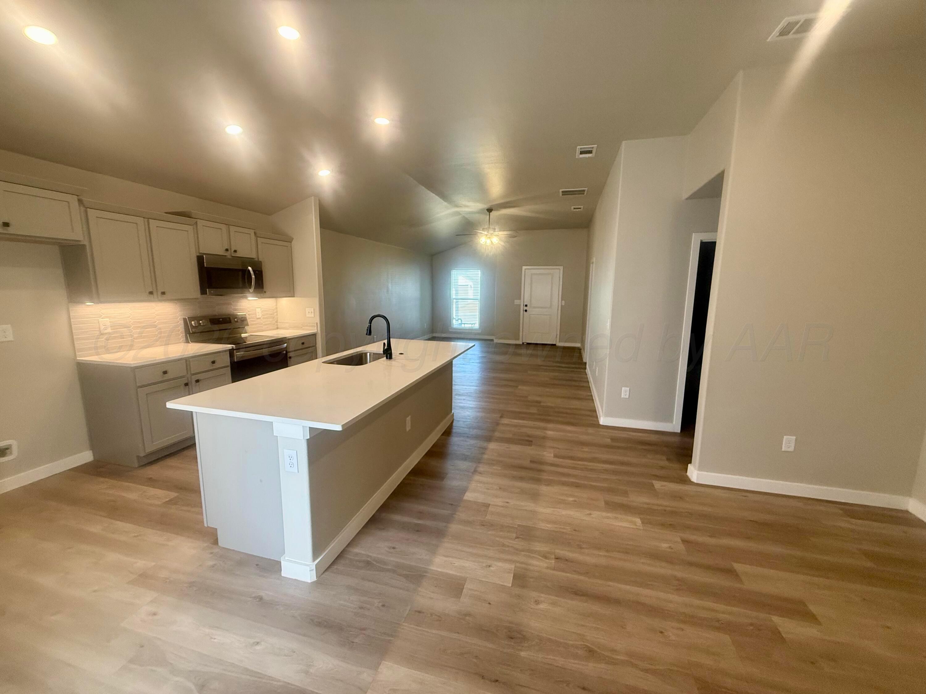 1529 Lullwater Road Amarillo, TX 79118 - Photo 8 of 29 a large kitchen with kitchen island a sink a stove a refrigerator and grey cabinets