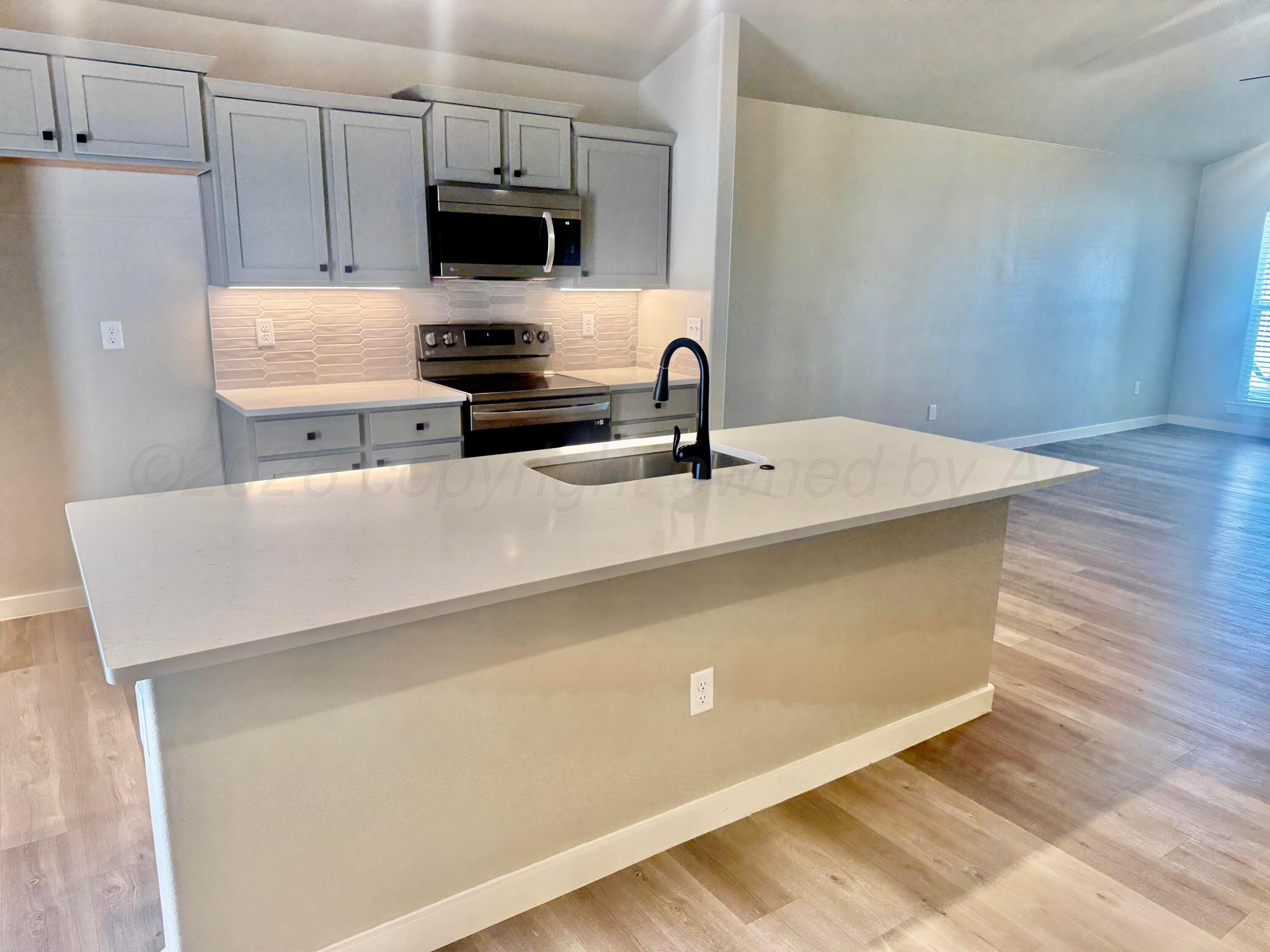 1529 Lullwater Road Amarillo, TX 79118 - Photo 9 of 29 a kitchen with a sink and a refrigerator