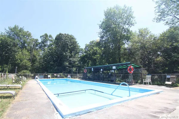 a view of a swimming pool with a bench and trees