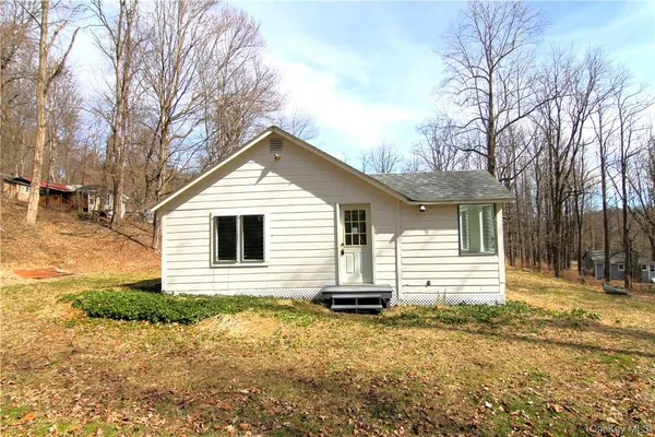 a front view of house with yard and trees around