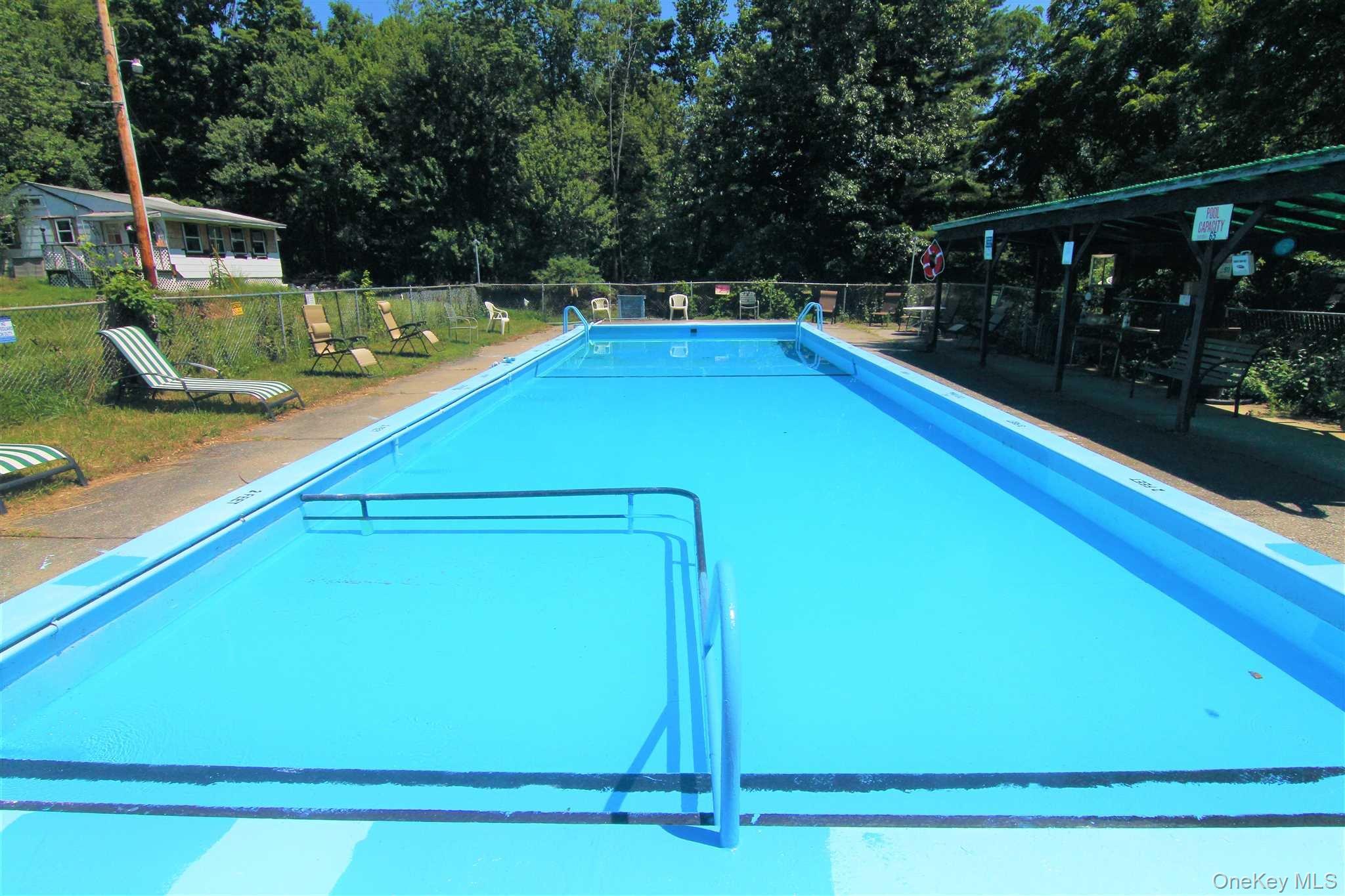 71 Miller Road, Unit 6 Hopewell Junction, NY 12533 - Photo 21 of 22 a view of a swimming pool with a bench and trees