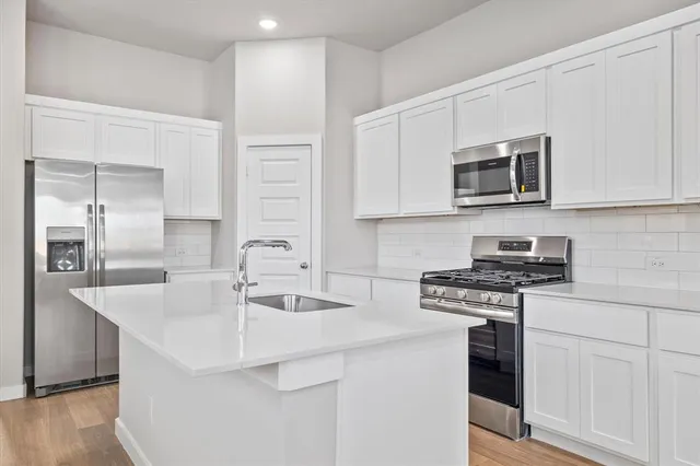a kitchen with stainless steel appliances granite countertop a sink stove and microwave