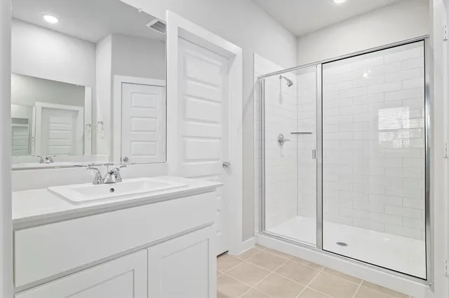 a bathroom with a shower sink and mirror