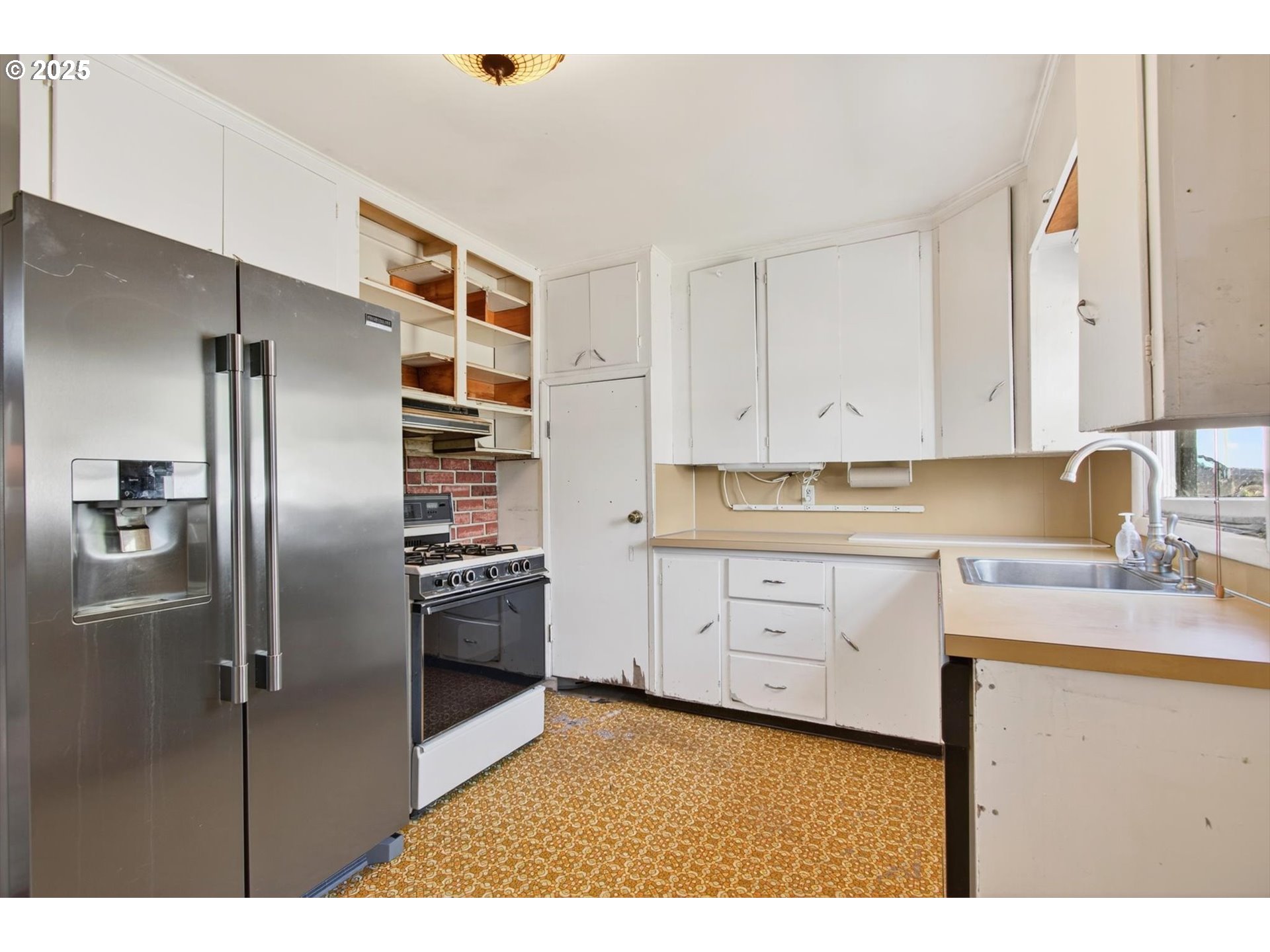 3945 Northeast Bryant Street Portland, OR 97211 - Photo 11 of 31 a kitchen with white cabinets and stainless steel appliances