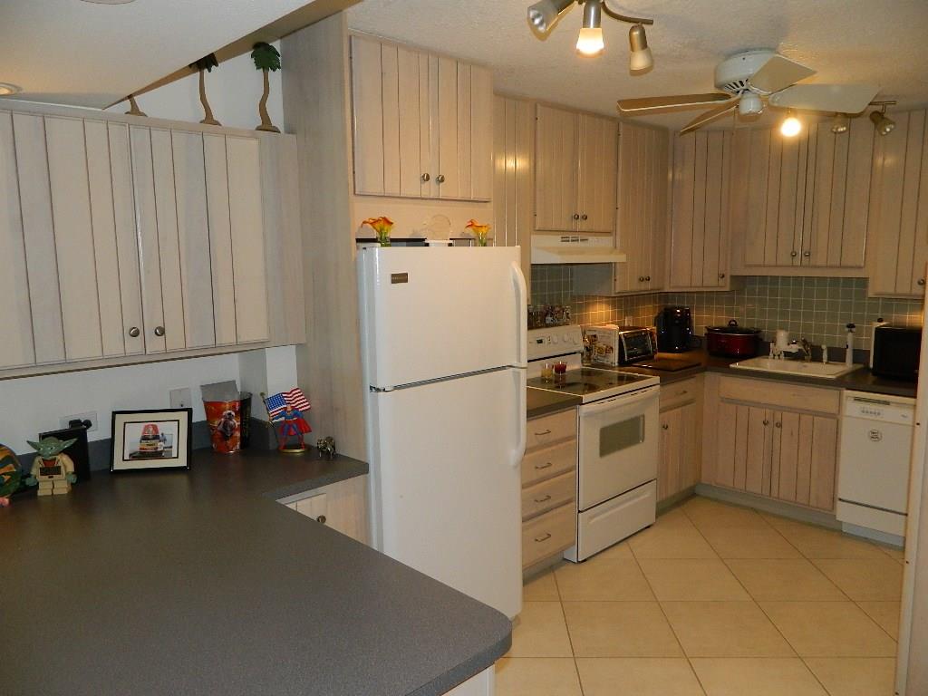 390 Golfview Road, Unit B North Palm Beach, FL 33408 - Photo 3 of 22 a kitchen with a sink a refrigerator and cabinets