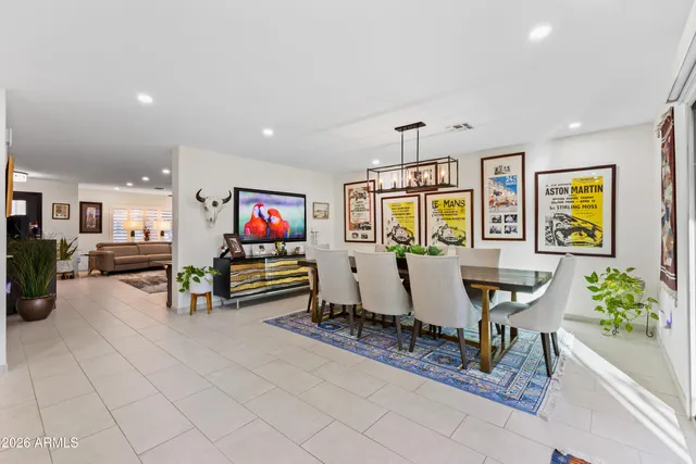 a kitchen with stainless steel appliances granite countertop a stove top oven a sink dishwasher a dining table and chairs with wooden floor